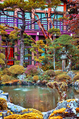 Fototapeta na wymiar Japan Travel Concepts. Traditional japanese Garden with Red Maples, Pond and Stone Lanterns on Mount Koyasan in Japan.