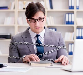 Businessman tied with chains to his work