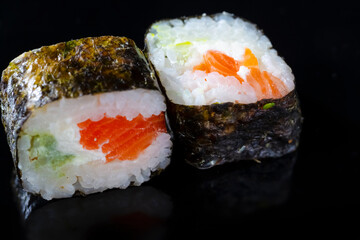 Macro Shoot of Two Traditional Sushi Rolls With Red Salmon Together on Black Surface