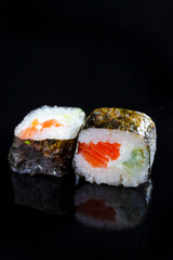 Macro Shoot of Two Traditional Sushi Rolls With Red Salmon Together on Black Surface.