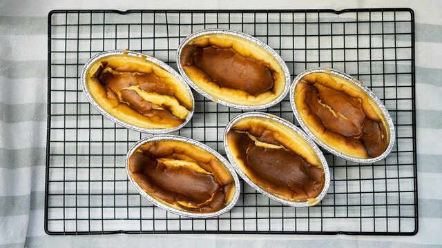 Top View of basque burnt cheesecake in foil cup on cooling rack