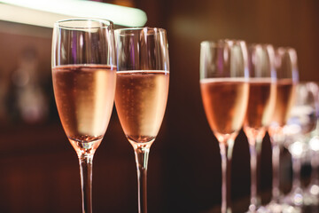 Line of alcohol setting on catering banquet table, bartender pouring beverages, row of different colored alcohol cocktails on a party, martini, vodka, and others on decorated banquet table event