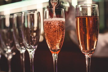 Line of alcohol setting on catering banquet table, bartender pouring beverages, row of different colored alcohol cocktails on a party, martini, vodka, and others on decorated banquet table event