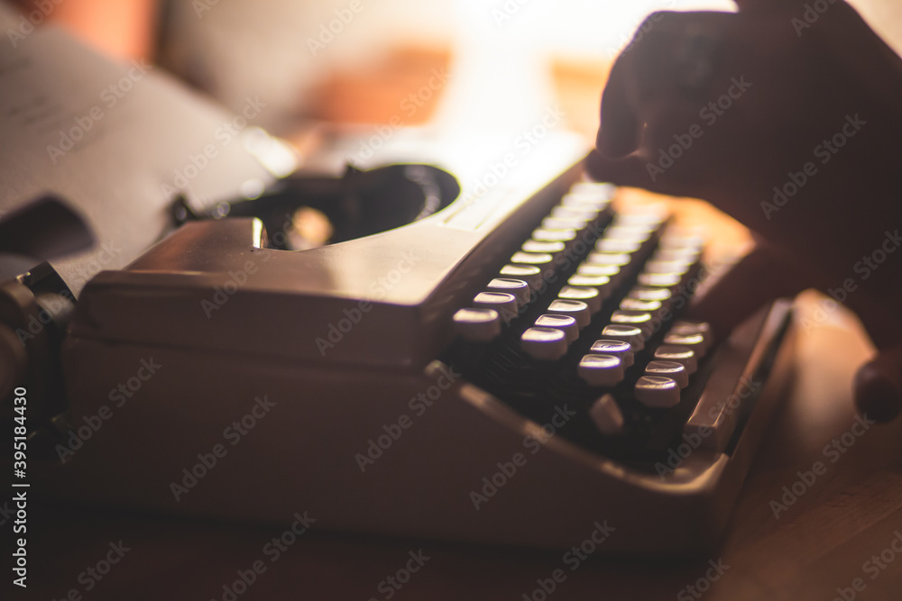 Fototapete process of writing a text letter on a white sheet of paper with old-fashioned typewriter, modern wri