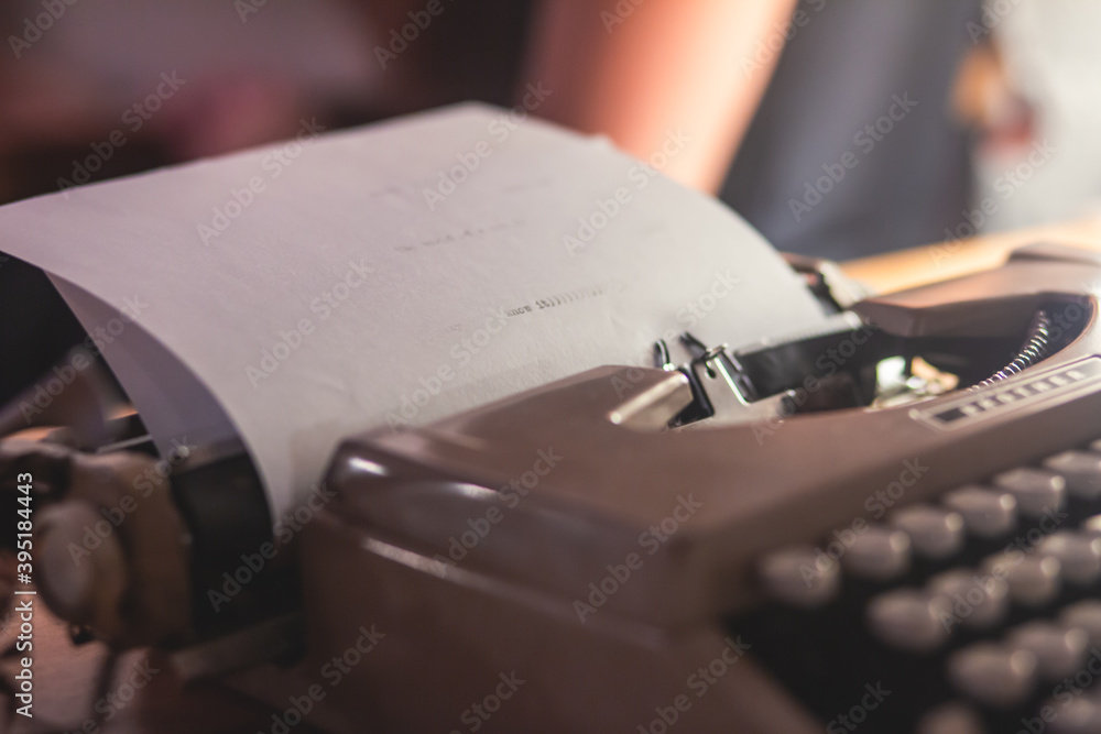 Fototapete process of writing a text letter on a white sheet of paper with old-fashioned typewriter, modern wri