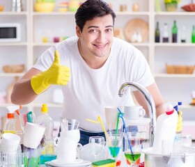 Man showing thumbs up washing dishes