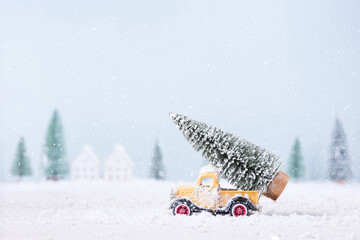 Christmas tree on toy car was running through the snow in the field of natural Landscape background