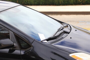 llegal parking violation ticket on a vehicle windshield