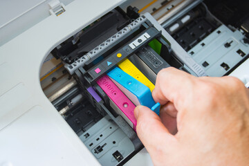 Technicians are install setup the ink cartridge of a inkjet printer the device of office automate...