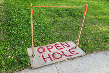 An Open Hole sign spray painted on plywood