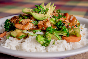 Delicious shrimp teriyaki with broccoli, pumpkin, carrot and rice in oyster sauce on a white plate.