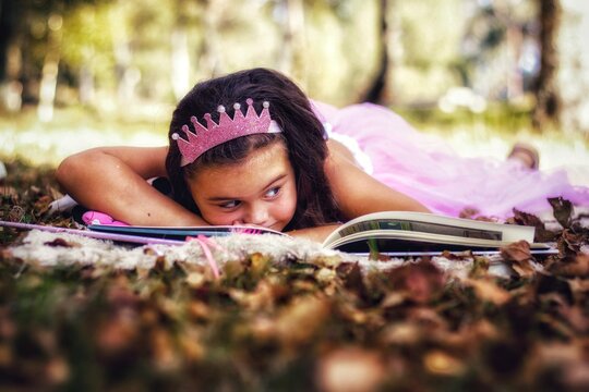 Girl Reading Book While Lying On Land