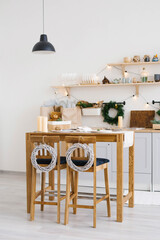 New year and Christmas. Festive Scandinavian cuisine in Christmas decorations. Candles, fir branches, wooden stands, table.