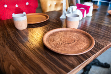 Clay plate and mug on wooden table in restaurant