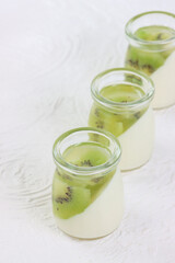 Puding buah kiwi. Kiwi fruit pudding in a glass on a white background.