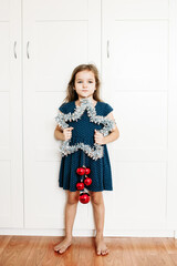 A girl holds a star in her hands to decorate the house for the new year and Christmas, the child is preparing for the holiday, helping parents, waiting for gifts