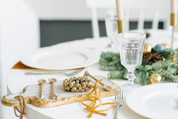 Christmas table setting. Classic decor with a wreath of Golden bells