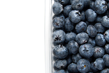 blueberries in clear plastic tray shot from above on white background.