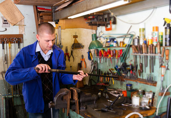 Lubricating and cleaning the barrel of rifle in a gun workshop