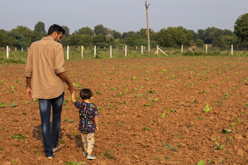 Indian Father and son duo walkig in farm