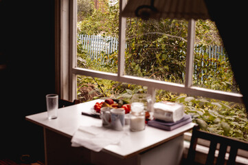 Beautiful summer view from the old window. Rustic wooden house. Table by the window. Silence of suburban life
