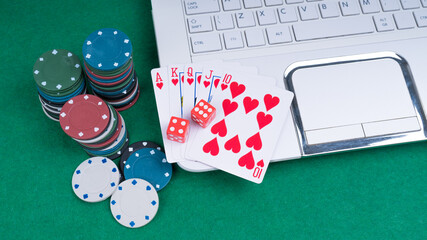 Cards cubes and chips on a laptop. Royal flush poker. Gambling concept, online casino