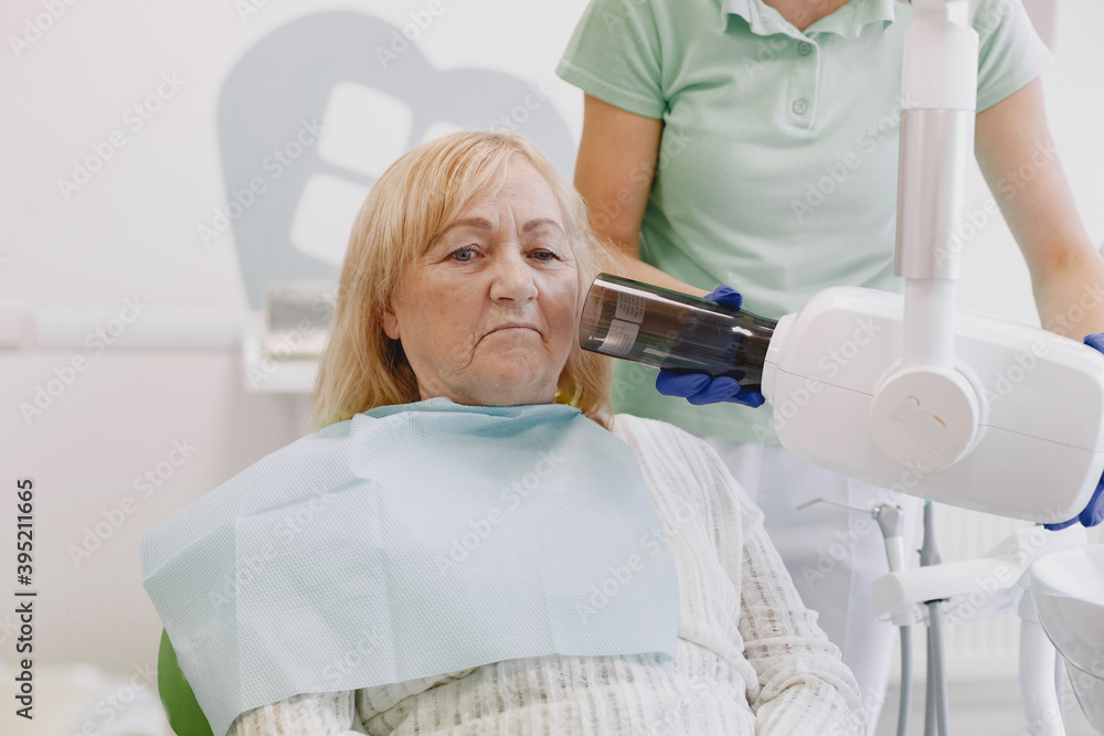 Wall mural Senior woman having dental treatment at dentist's office. Woman is being treated for teeth.