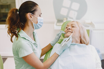 Senior woman having dental treatment at dentist's office. Woman is being treated for teeth