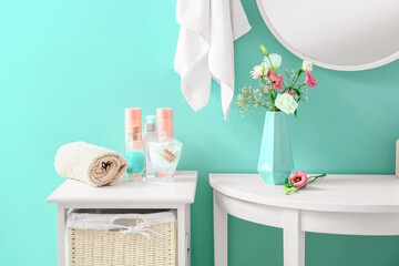 Beautiful vase with flowers and bath accessories in stylish bathroom
