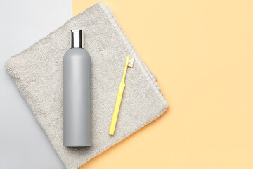 Shower gel and toothbrush on color background