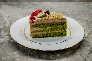Homemade spinach cake decorated with raspberries and chocolate