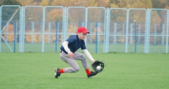 Baseball tournament at school, the boy pitcher run and successfully catches a fastball in the glove, sends a pass to another player, 4k slow motion.