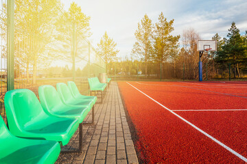 Outdoor basketball court with empty chairs