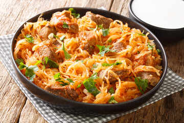 Delicious stewed sauerkraut with pork, onions and paprika close-up in a plate on the table. horizontal