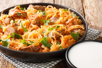 Sauerkraut stew with pork and paprika close-up in a plate on the table. horizontal