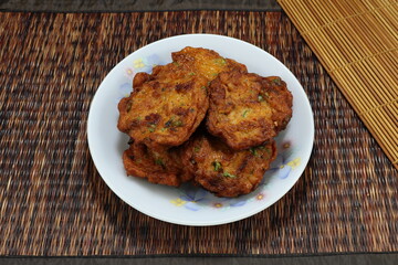 Pile of deep fried Thai Food Curried fish cake on the plate. Famous traditional baked chilly paste ball in Asia restaurant. 