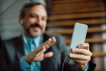 Close-up of businessman using mobile phone for a video call from the office.