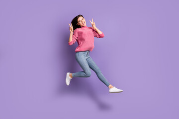 Fototapeta na wymiar Full length body size photo of jumping high female student showing v-sign gesture isolated on bright violet color background