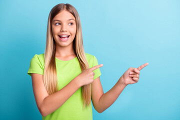 Photo of young cheerful positive good mood smiling girl pointing fingers copyspace isolated on blue color background