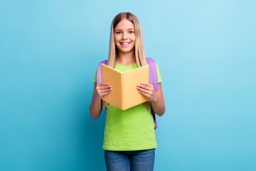 Photo of young happy positive good mood girl reding book wear purple rucksack isolated on blue color background