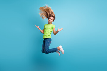 Photo portrait of funny girl jumping up isolated on pastel blue colored background