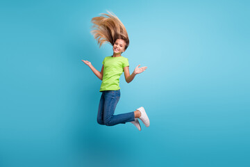 Obraz premium Photo portrait of funny girl jumping up isolated on pastel blue colored background