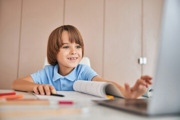 Naklejka premium Kid joining his online lesson and feeling happy