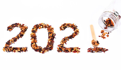 2021 numbers made of herbal orange and citrus tea leaves and a cup of orange tea, wooden spoon. Happy New 2021 Year celebration. Tea and New Year concept.