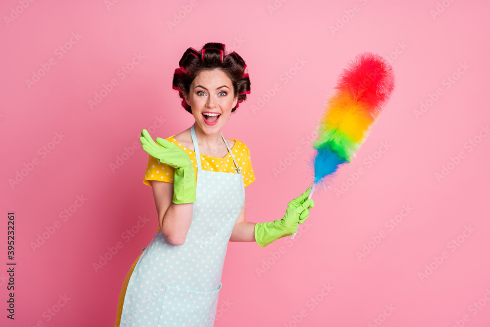 Poster portrait of shocked maid hold soft duster wear dotted t-shirt latex gloves isolated on pastel color 