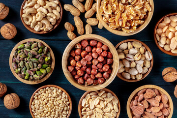 Nuts variety flat lay. Many different nuts, shot from the top on a dark blue background