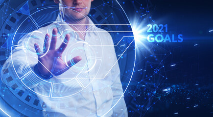 Business, Technology, Internet and network concept. Young businessman working on a virtual screen of the future and sees the inscription: 2021 goals