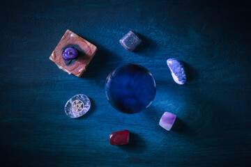 Divination. A magic ball, shot from the top with crystals and a candle on a dark background