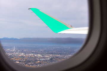 飛行機の窓から上昇中の景色とウィングレット