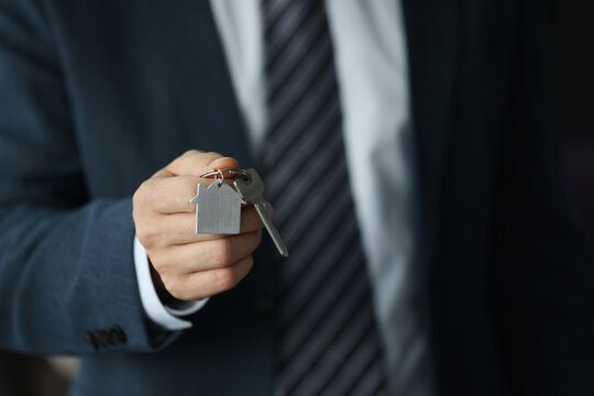 Silhouettes of businessman holding keys in hand. Receiving real estate keys concept